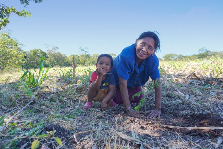 Farmer Dora Maria Salgado planting a tree with her son